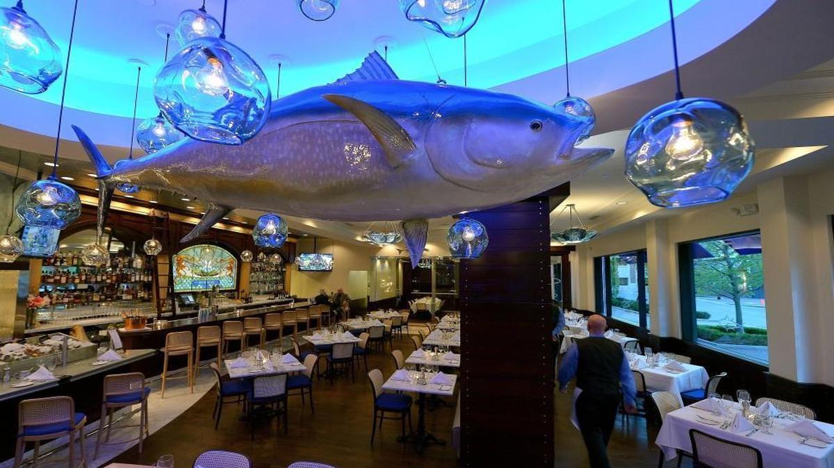 Dining tables under a hanging blue tuna and hand blown glass lights were features of 801 Fish’s decor.