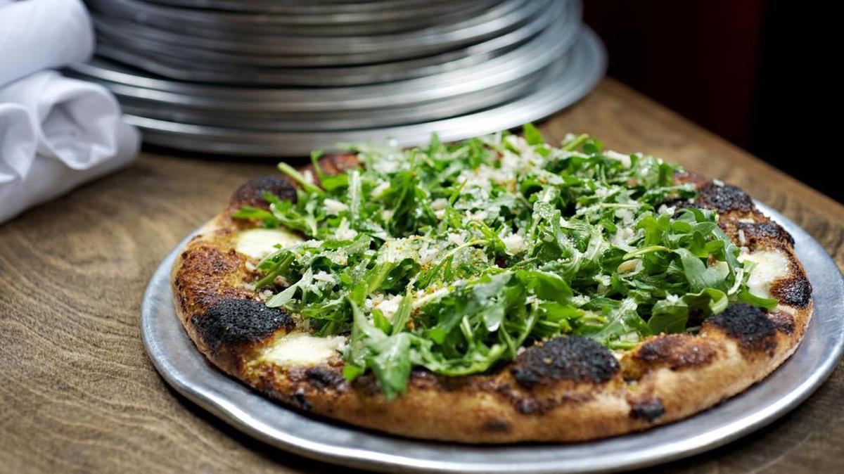 Zavino’s The Stache pizza with whole wheat crust, pistachio pesto, mozzarella, Parmesan, lemon vinaigrette and baby arugula.