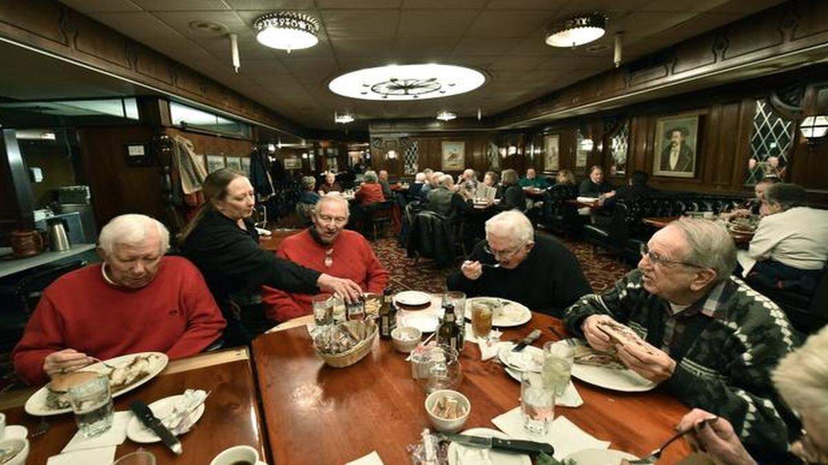 
Sheila Leonard (second from left) of the Golden Ox served retired employees of the Business Men’s Assurance Company of America at lunch Wednesday, including Jack Cooper (seated from left), George Calvert, Everett Fisher and Tony Rinella.
