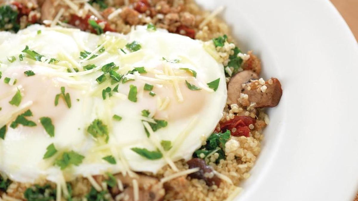 The Power Breakfast Quinoa Bowl with two basted eggs on quinoa with Italian sausage, house-roasted crimini mushrooms and tomatoes, kale, Parmesan and extra virgin olive oil.