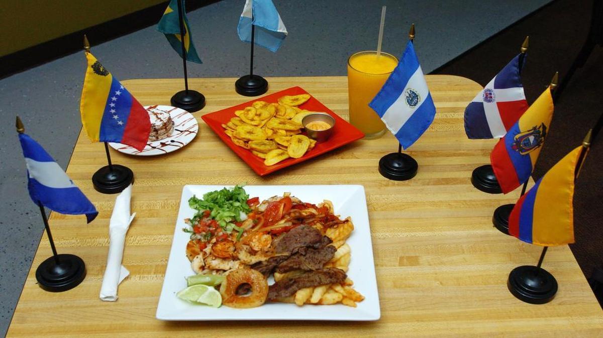 
Sabor Latino’s Mar y Tierra (center) has shrimp, chicken, steak, cinnamon pineapple, onions and tomatoes over a bed of fries. An appetizer of fried plantains is served with chipotle sauce, and marquesa (above left) is served for dessert. To top it off, sip on maracuya, a nonalcoholic frozen passion fruit drink. The flags represent some, but not all, of the countries represented on the menu of Sabor Latino in Lee’s Summit.
