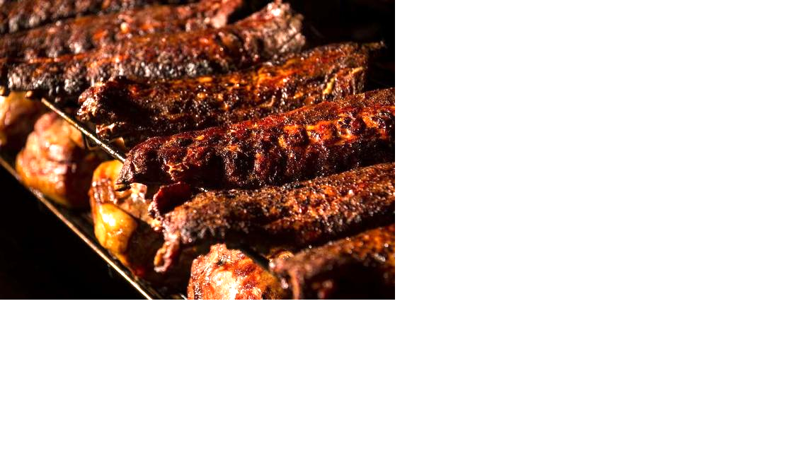 Ribs cook on a smoker carousel at Fiorella’s Freight House location.
