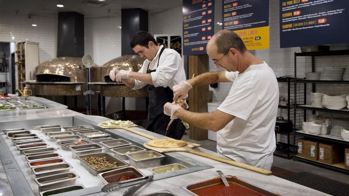 John Huckabay (left) and Roberto Timotei prepare pizzas at 1889 Pizza Napoletana.