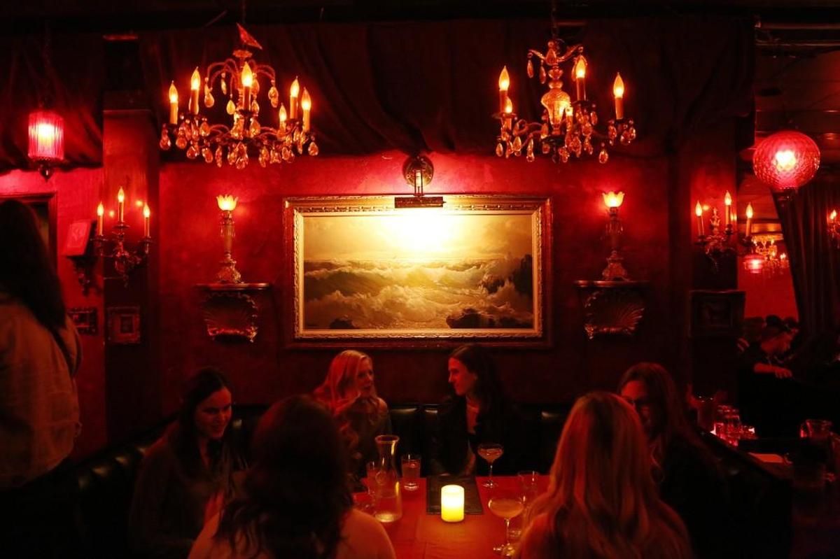 The Green Lady Lounge jazz club glows with red lights and vintage decor.