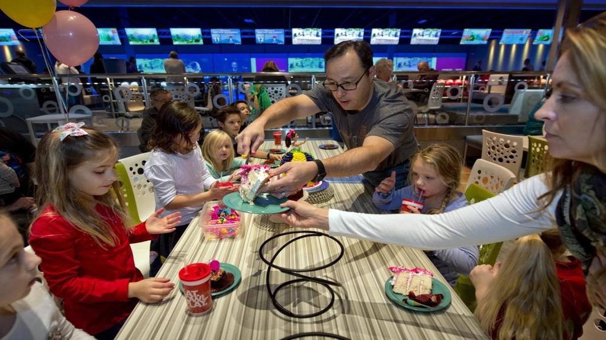 The Main Event Entertainment center has opened at 4600 Cochise Court in Independence. David and Stephanie Windhausen of Lee's Summit served up cake Saturday at a birthday party for their daughter, Hollie (third from left), who is 8. The center's bowling lanes are in the background.