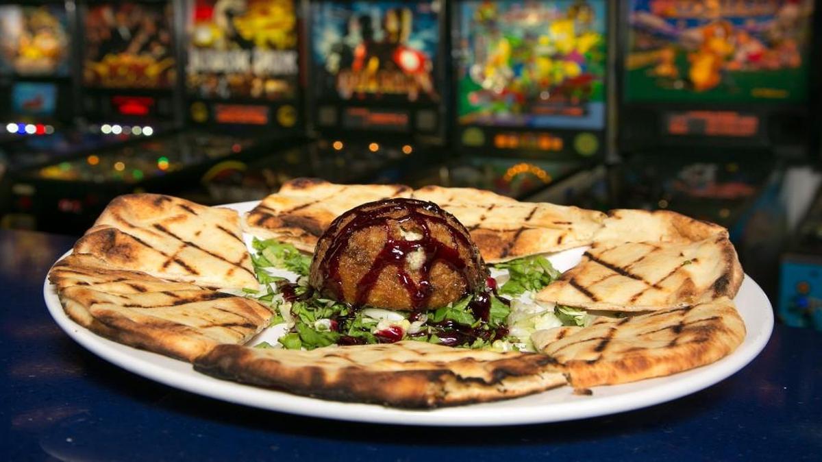 Fried Boursin cheese is served with toasted naan bread and raspberry puree at Draftcade in Zona Rosa.