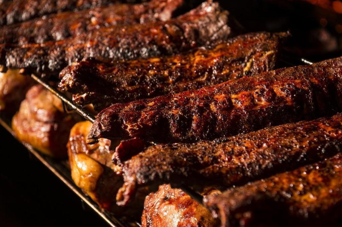 Ribs cook on a smoker carousel at the Freight House location of Fiorella’s Jack Stack Barbecue.