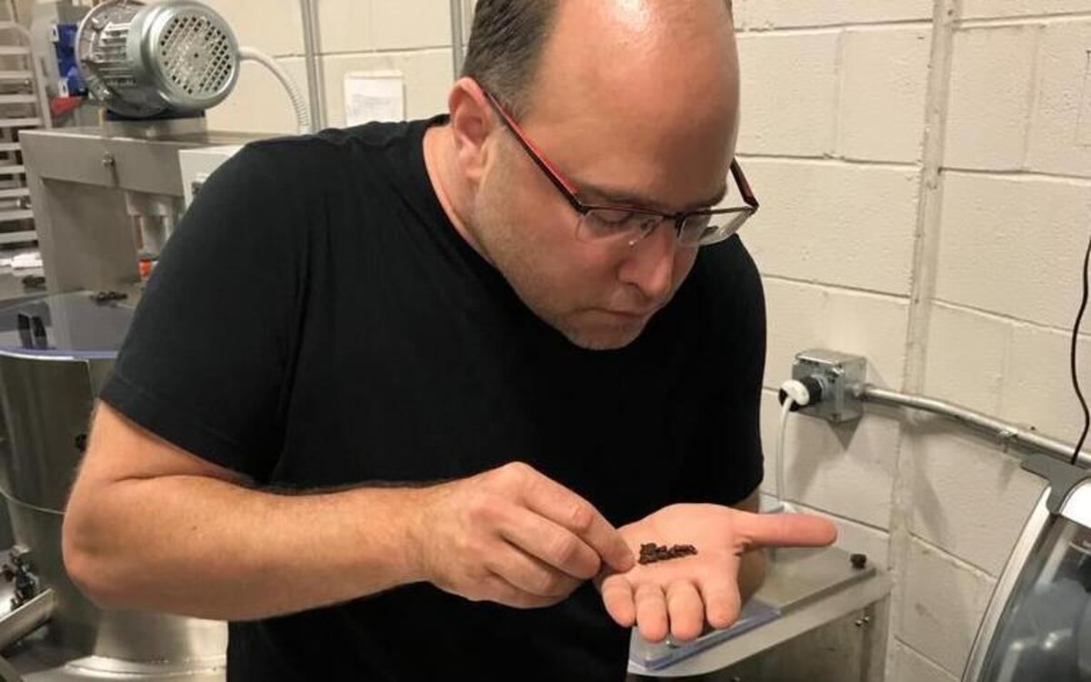 Christopher Elbow examines cacao beans he has roasted at his test kitchen on Southwest Boulevard.