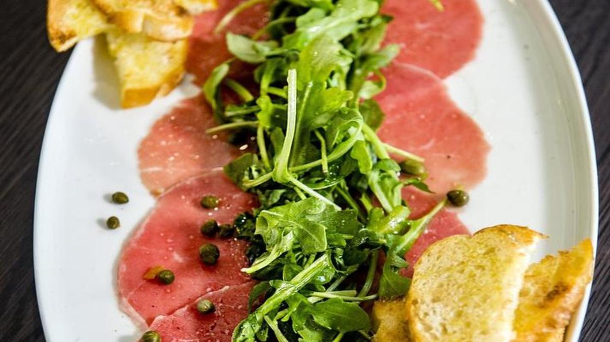 The carpaccio features beef filet, caper, truffle oil, arugula and croutons.