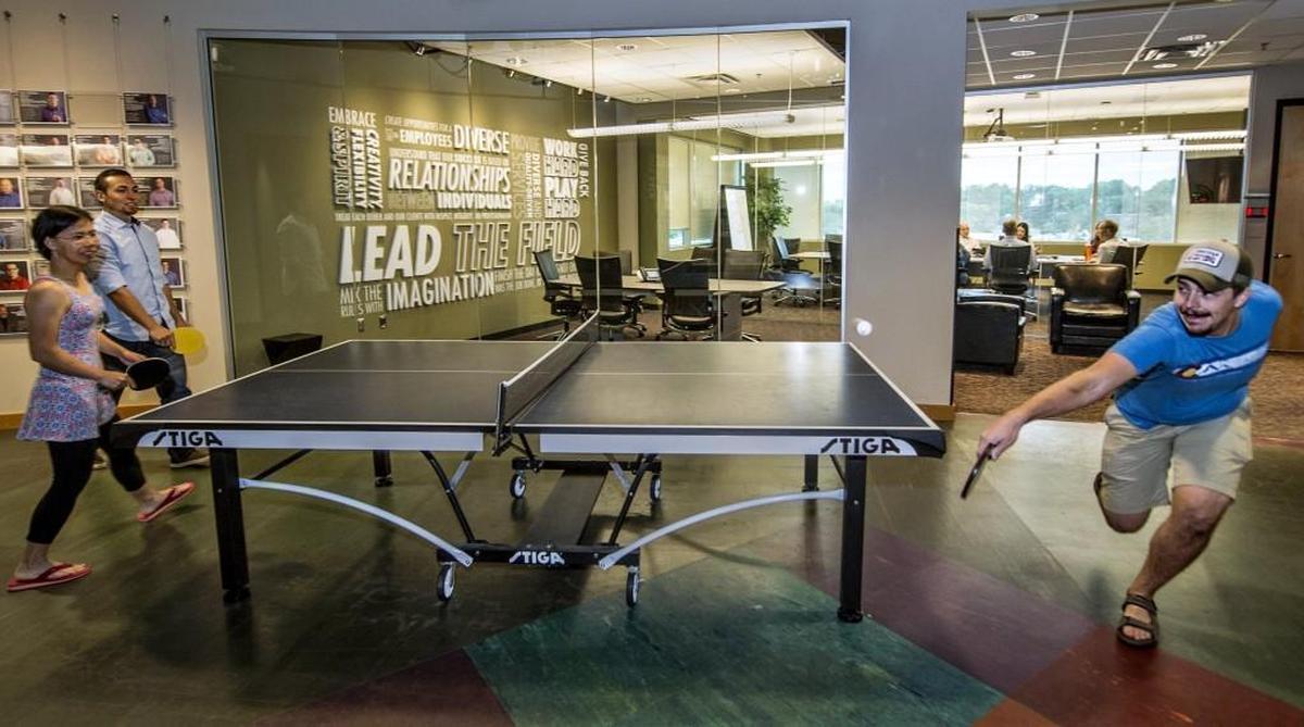 Henderson Engineers designers (from left) Kim Pham, Eric Rodda and Jason Cornett played pingpong on a recent Tuesday afternoon. The table is located in the Lenexa firm’s lobby, just steps away from conference rooms reserved for business meetings.