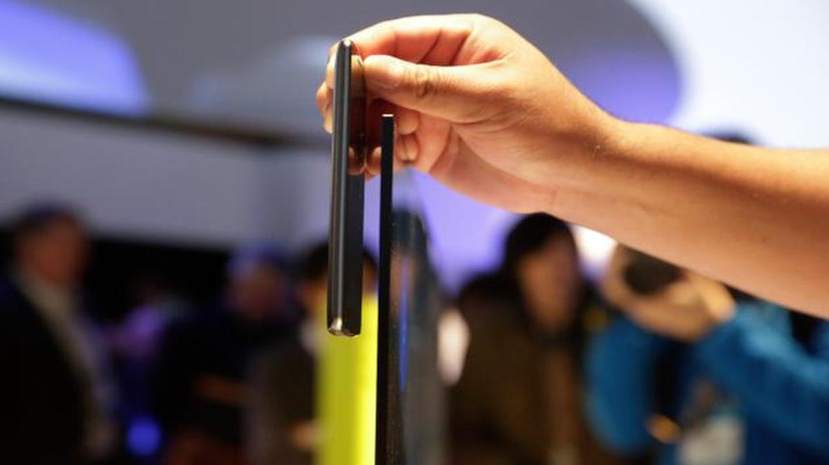 
An attendee at this week’s International CES show placed his smartphone next to Sony’s 65-inch X900 C series 4K Ultra HD TV to compare the thickness. The display is less than 0.2 inches thick at its slimmest point. 
