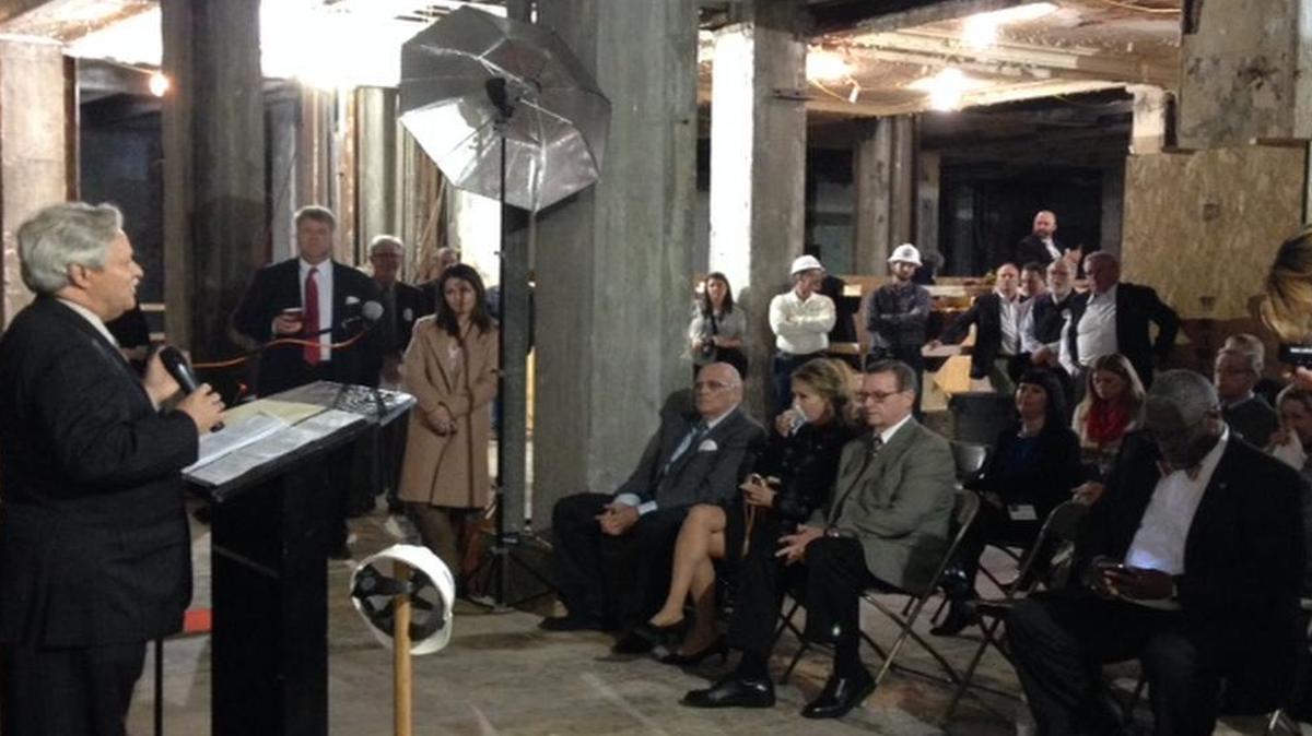 Developer Thomas Smith, seated, center front row, hears development adviser Bob Mayer address Mayor Sly James, City Manager Troy Schulte and others gathered for a renovation celebration in the Pickwick Hotel and bus terminal in downtown Kansas City.
