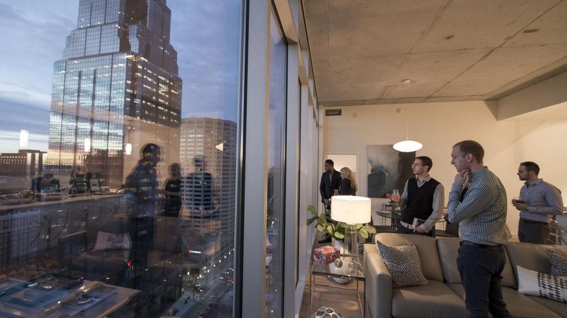 Sean Ray (foreground) and R.J. Stebbins (to the left of Ray) admired the view of downtown from one of the penthouses on the 26th floor during a party Tuesday to officially open the One Light apartment building. Ray and Stebbins will become roommates in One Light next month.