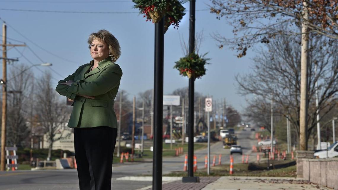 Missy Wilson, executive director of the Martin City Community Improvement District, stands near new planters on new sidewalks on 135th Street. Orange cones show work on the next phase of improvements.