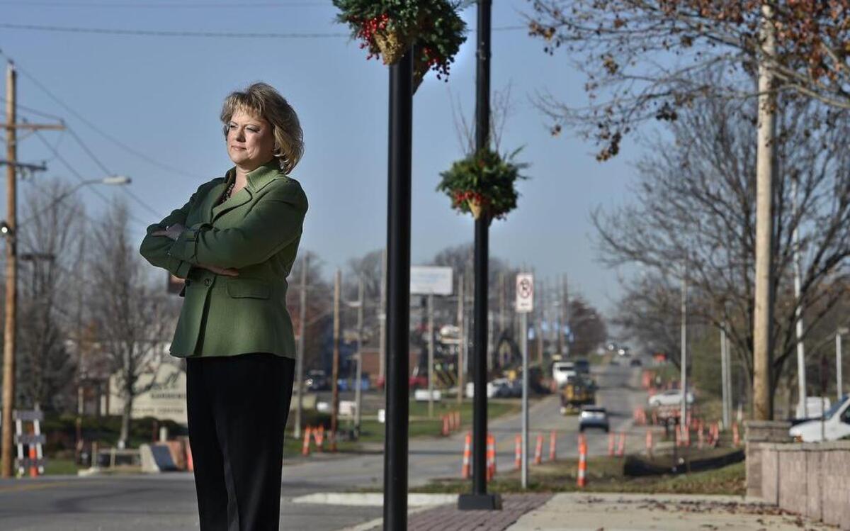 Missy Wilson, executive director of the Martin City Community Improvement District, stands near new planters on new sidewalks on 135th Street. Orange cones show work on the next phase of improvements.