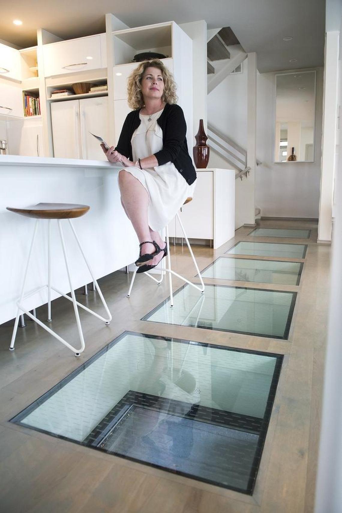 Jamie Lewis, 49, enjoys the light, bright interior of the home she purchased in 2015 for just over $500,000 in Beacon Hill. Glass panels in her floor provide a view of an outdoor sitting area and gas fire pit below.