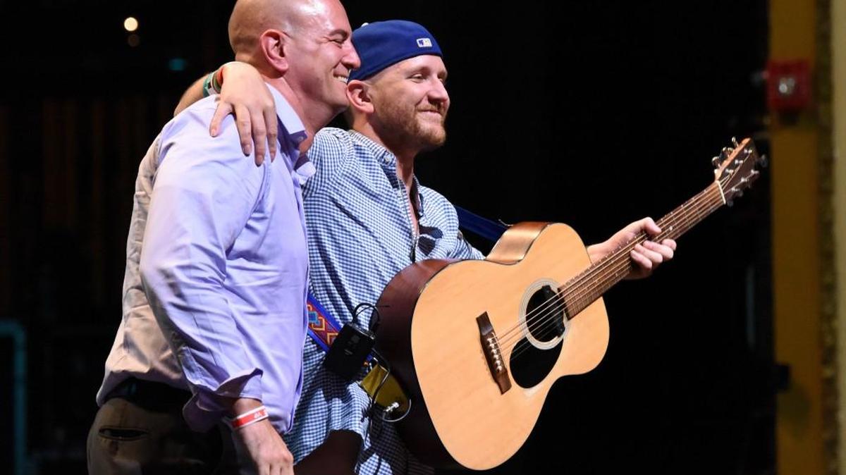 Children’s Mercy Hospital oncologist Doug Myers, left, celebrates with Lucas Novick on stage during the Big Slick Celebrity Weekend benefit in June. Novick, a Nashville musician, was part of a groundbreaking gene therapy study at Children’s Mercy Hospital that sent his leukemia into remission and has now been approved for commercial use.