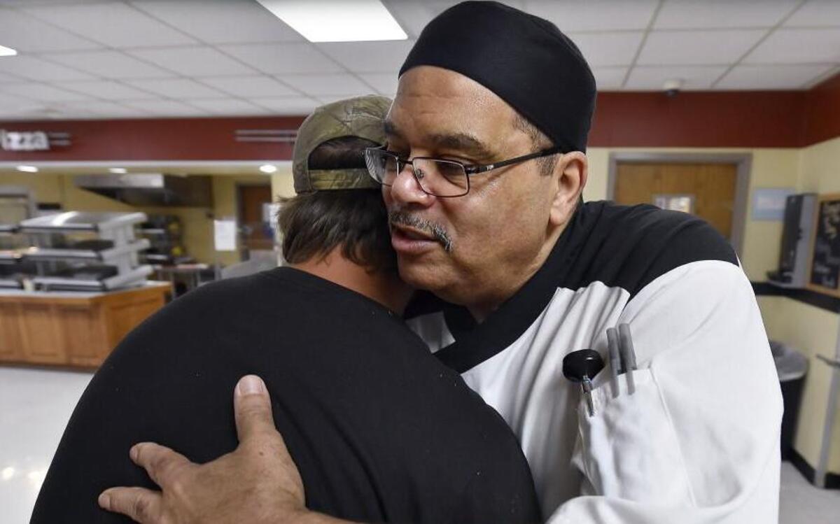 Thomas Allen (right) a third-shift kitchen supervisor at the KU Hospital cafeteria, uses his background as a minister at a local church to comfort late-night customers who are struggling with their loved ones’ hospitalization. Allen and Jake Presnell of St. Joseph shared a hug recently.