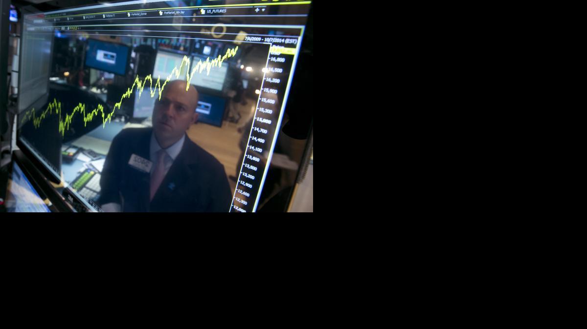 
Jay Woods is reflected in a screen at his post that shows five years of the Dow Jones industrial average
