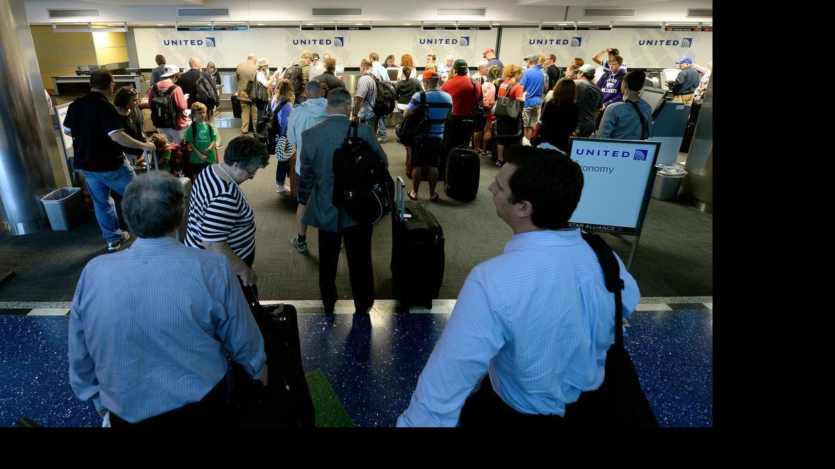 
United Airline passengers crowd the check-in counter at Kansas City International Airport Wednesday morning after the airline’s computer system was restored after a brief shutdown that grounded all United flights.
