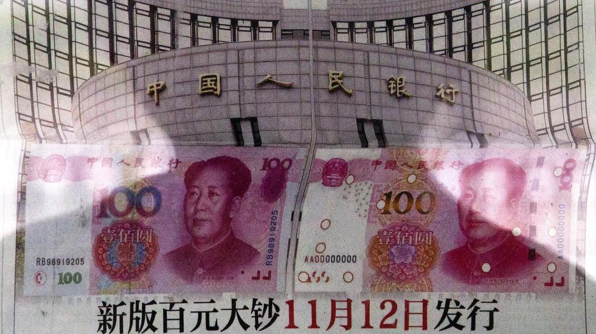 
A shadow of a man was reflected on a glass as he read a newspaper Tuesday in Beijing.
