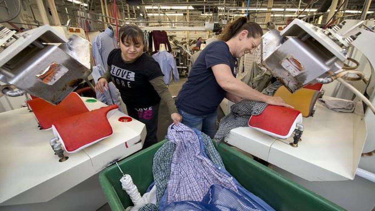 Catalina Martinez (left) and Tammy Hill press shirts at Arrow Fabricare Services, 3838 Troost Ave., which is celebrating its 100th anniversary this year.