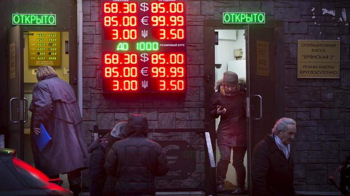 
People in Moscow waited to exchange their currency Tuesday as signs advertised the exchange rates. The Russian ruble came under intense selling pressure, falling at one point a catastrophic 20 percent.
