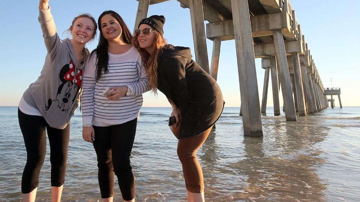 Visitors from Australia, take a selfie along the beach in Panama City Beach, Fla. (