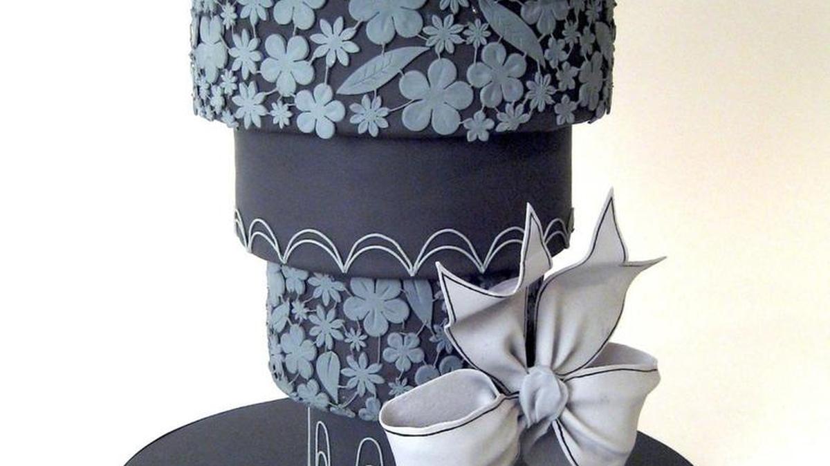 An an upside-down wedding cake frosted in black.