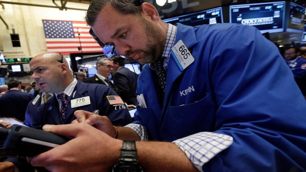 
Traders Fred DeMarco, left, and Kevin Lodewick, right, work on the floor of the New York Stock Exchange during another wild ride Tuesday. 

