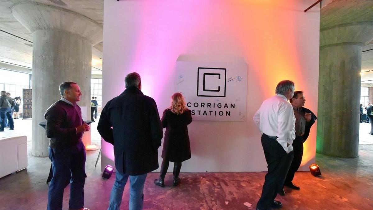 A Corrigan Station poster is signed by attendees during Thursday's ribbon cutting and tour of the office building at 19th and Walnut Streets in Kansas City, Mo.