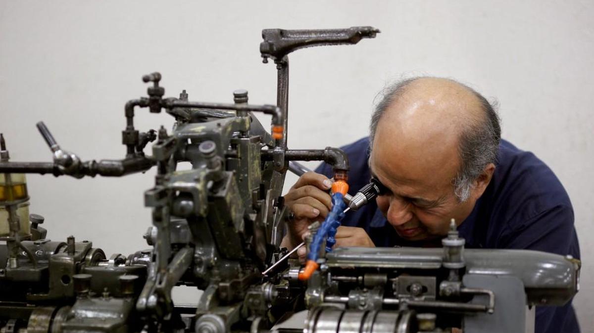 A technician repairs a machine on the factory floor at the Cox Manufacturing Co. facility in San Antonio, Texas.