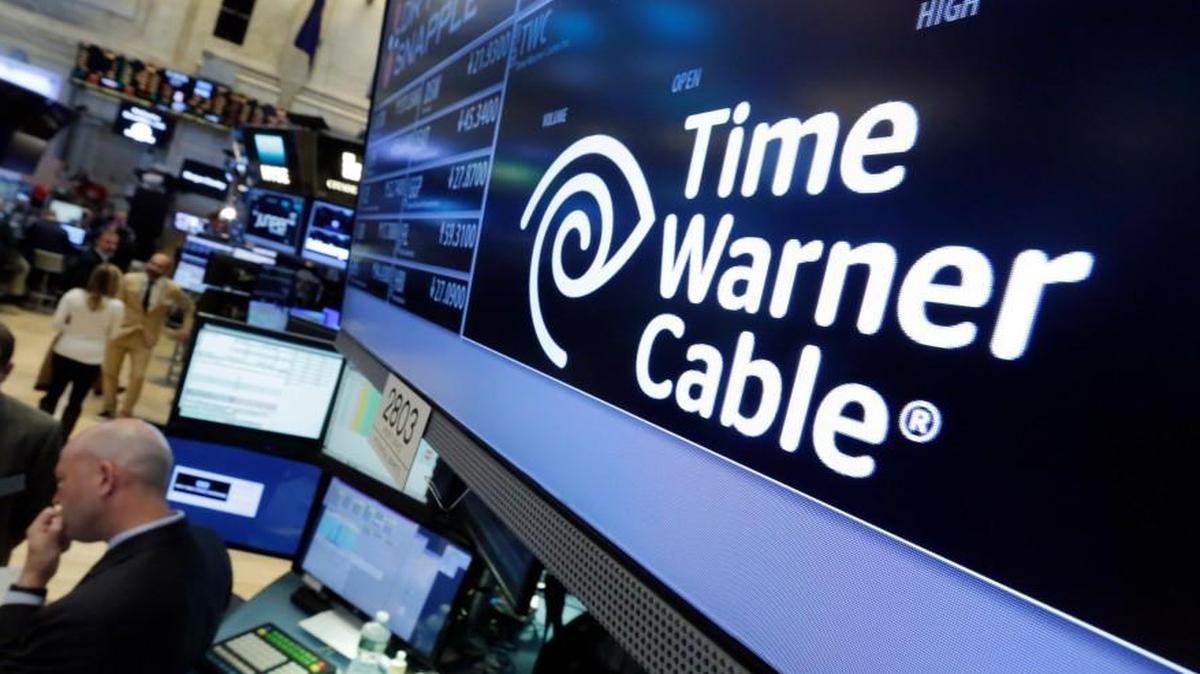 In this Tuesday, May 17, 2016, photo, the Time Warner Cable logo appears above the post where it trades on the floor of the New York Stock Exchange. Charter Communications closed on its $67 billion acquisition of Time Warner Cable and Bright House Networks. The deals made Charter the second-largest home Internet provider and third-largest video provider in the U.S.