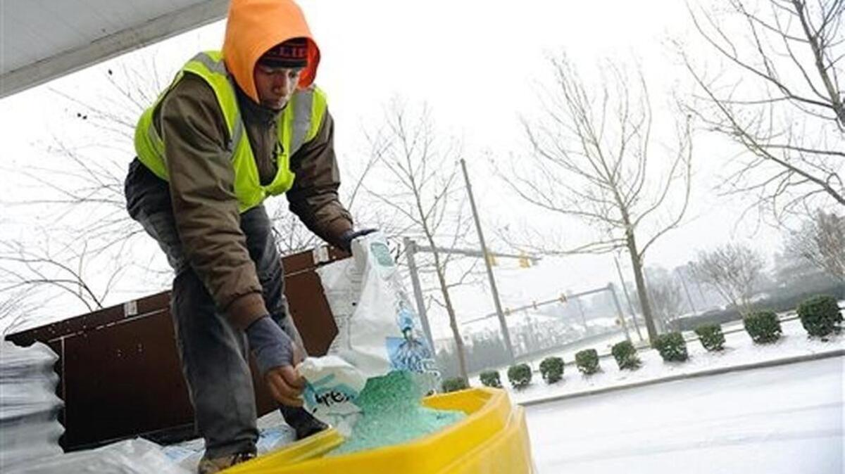 Ricky Nickerson added ice melt to a spreader in Durham, N.C., where a blizzard starting dumping heavy snow on Friday.