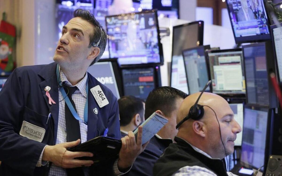 Gregory Rowe (left) with the Livermore Trading Group kept an eye on stock prices Friday at the New York Stock Exchange.