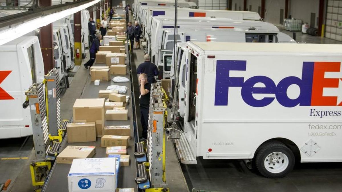 In this file photo, employees loaded boxes onto local deliver vehicles while sorting packages at a FedEx distribution facility in Kansas City.