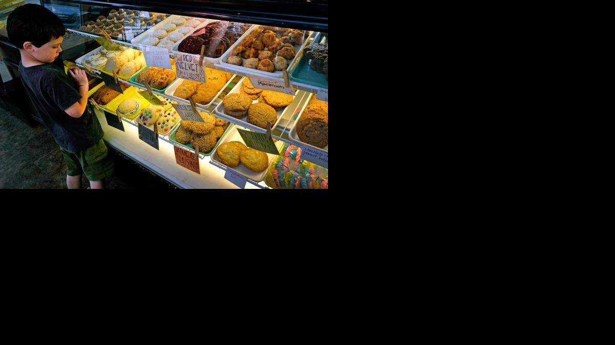 <137>McLain's Bakery & Coffeehouse at 201 E. Gregory Blvd., has new ownership, but the family that has run it for years still is involved.<137> Five-year-old Jack Pinney of Lee’s Summit, above, surveyed the display case of treats <137>goodies<137> Thursday morning with his father, Chris, who had heard about the shop from his boss.