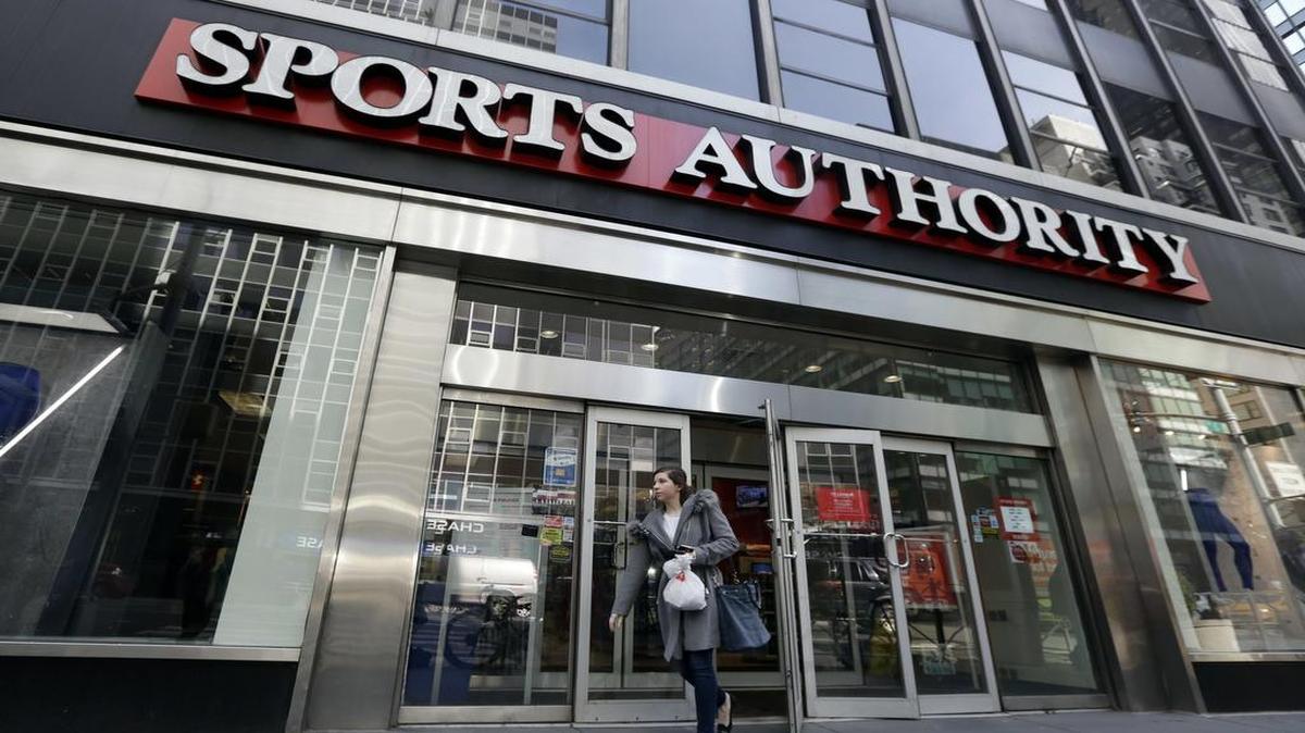 A woman leaves a Sports Authority store Wednesday in New York.
