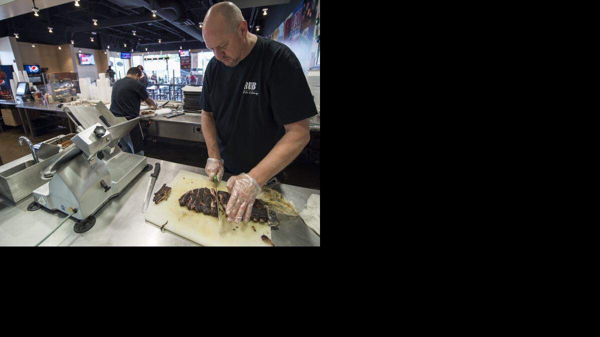 
Mike Wagers cut ribs Friday while filling an order at Dan Janssen’s Rub Barb-B-Que & Catering in Olathe.
