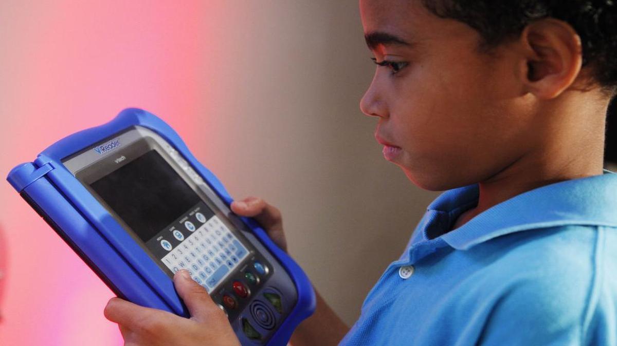 A boy looks at VTech’s V.Reader, an interactive e-reader for children.