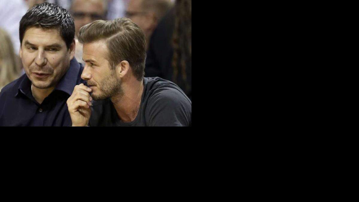 
Marcelo Claure (left) sits courtside with soccer star David Beckham.
