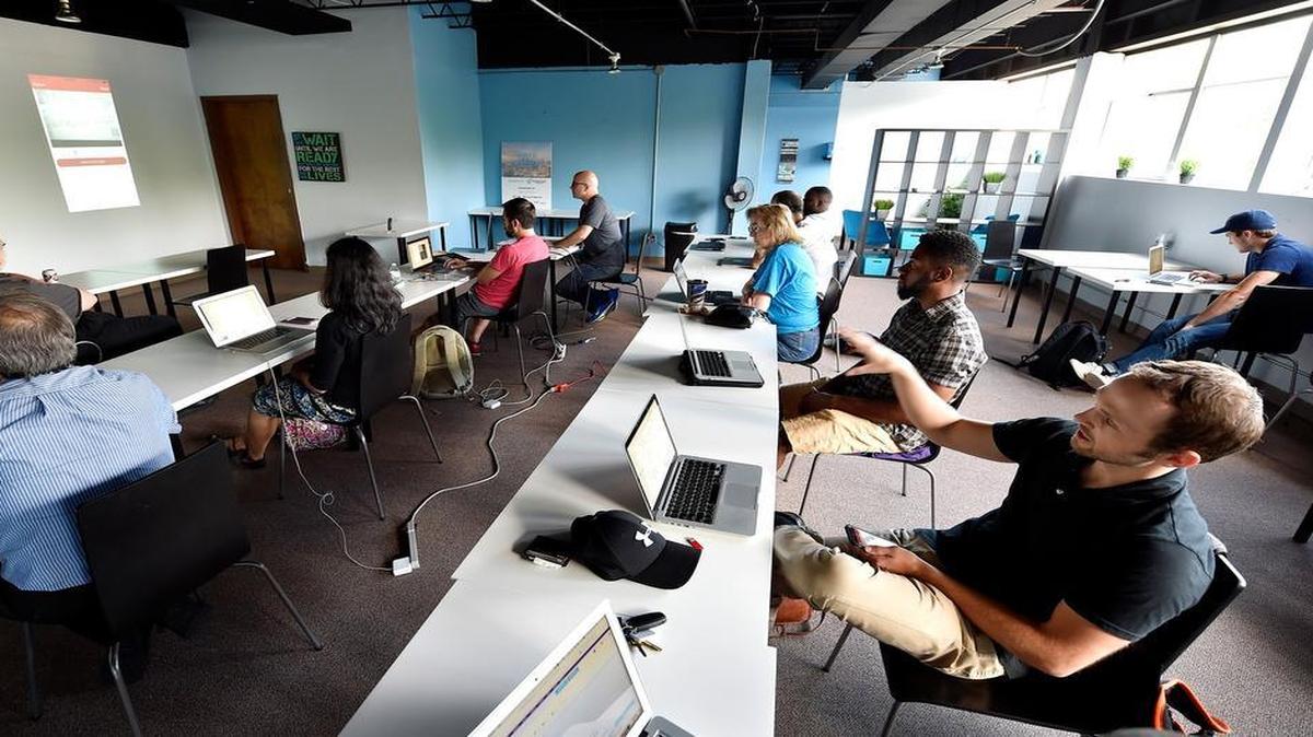 
During a recent class at the Disruption Institute, a new coding school in Kansas City, Travis Spire-Sweet (right) explained a mobile app he created. The class is designed to encourage more people to enter the tech industry.

