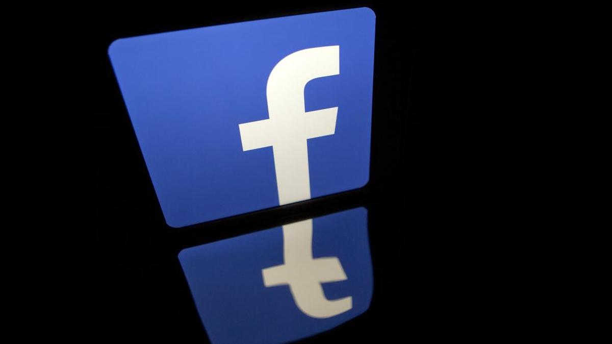 The Facebook logo is displayed on an Apple iPad Air.
