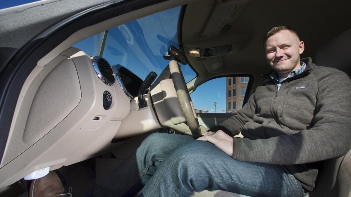 Taylor Clauson of Overland Park uses the Zubie, an electronic device that plugs into a vehicle’s OBD-II port (white box, lower left) under the dashboard to monitor and diagnose data.