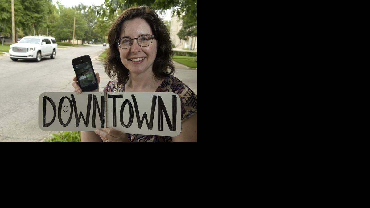 
In Lawrence, Jenny O'Brien displays her CarmaHop app and a whiteboard used to display the destination.
