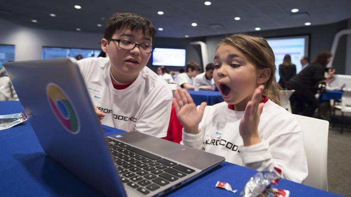 
Isabella White (right), a Crossroads Academy student, reacted as she solved a coding puzzle with some help from Sam Keeney, a Foreign Language Academy student, during an Hour of Code event Tuesday at Google Fiber Space.
