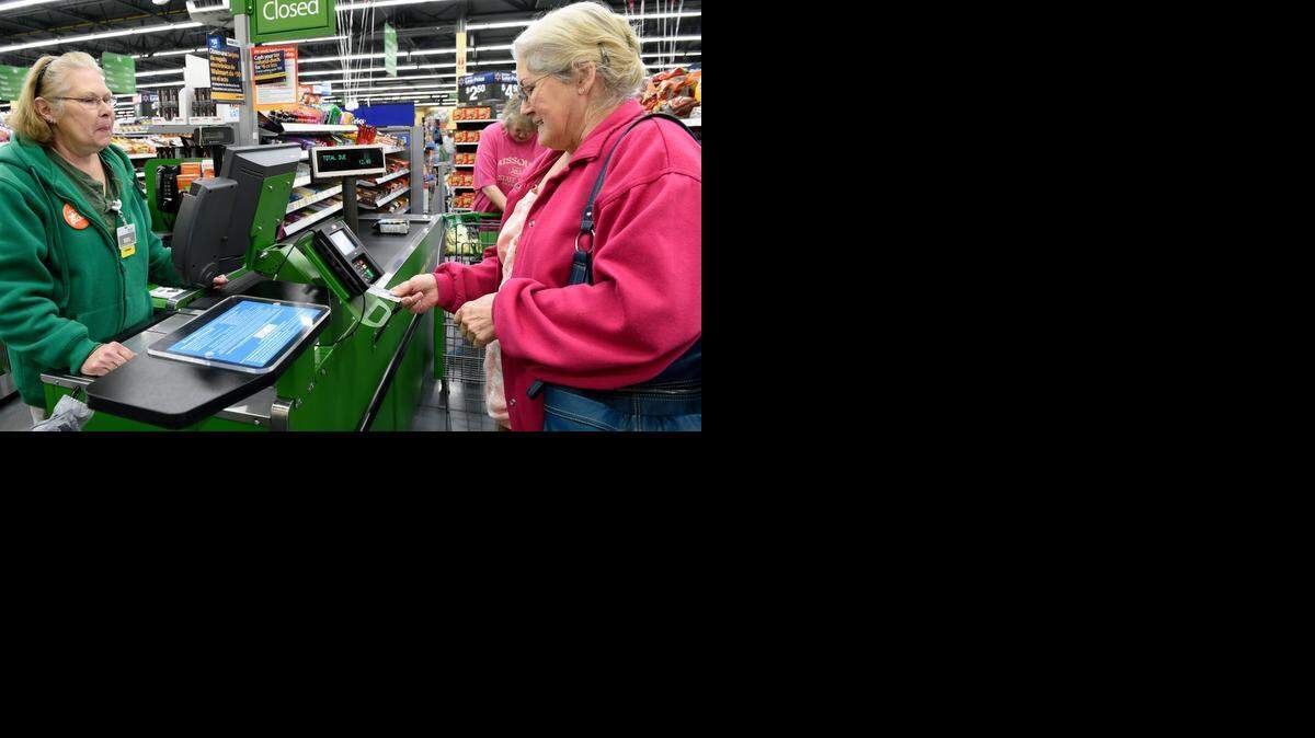 
Bobbie Kuhns (right) of Kansas City uses a card with a microchip in it to check out after getting groceries at a Wal-Mart store in Kansas City, Kan. At left is cashier Marjorie Miller.
