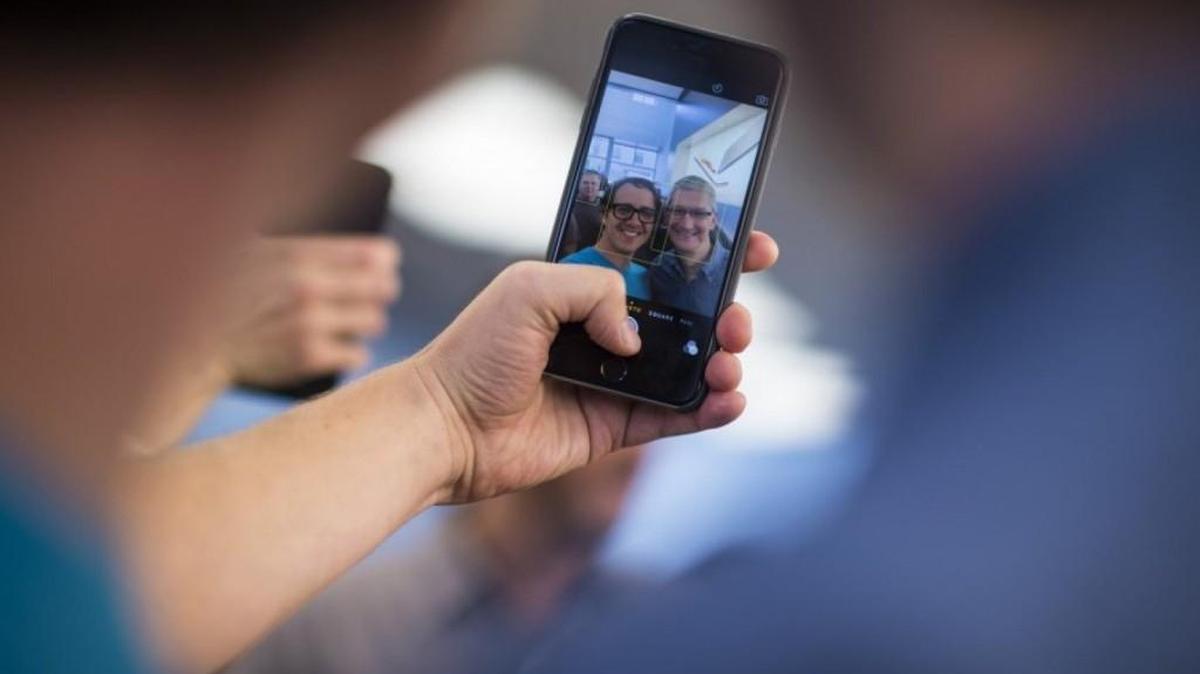 
A man takes a selfie with Apple CEO Tim Cook as he talks with employees and customers on a surprise visit to the Georgetown Apple store in D.C. Illustrates IPHONE-COOK (category f), by Andrea Peterson (c) 2015, The Washington Post. Moved Friday, Sept. 25, 2015. (MUST CREDIT: Washington Post photo by Jabin Botsford)
