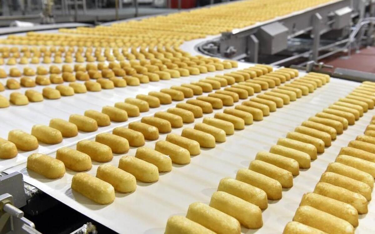 Freshly baked and filled Twinkies move down the conveyer belt to the packaging area at the Hostess Brands snack cake plant in Emporia, Kan. Monday, Hostess Brands started trading on Nasdaq under the ticker symbol TWNK.