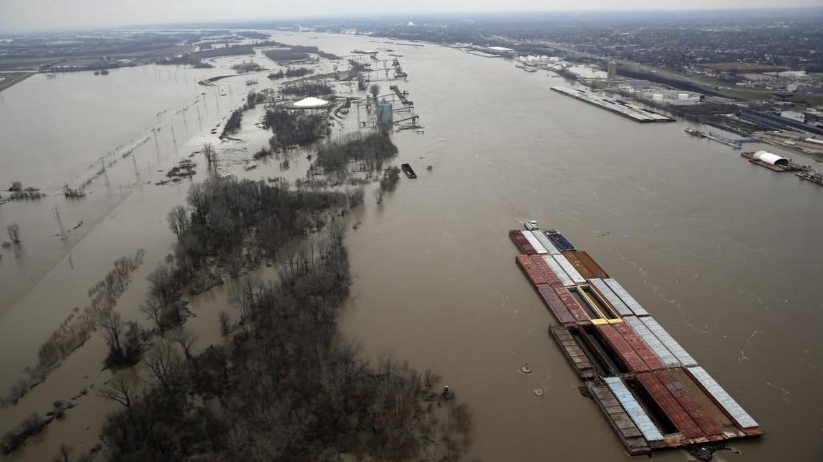 Barges ride the swollen Mississippi River near St. Louis.